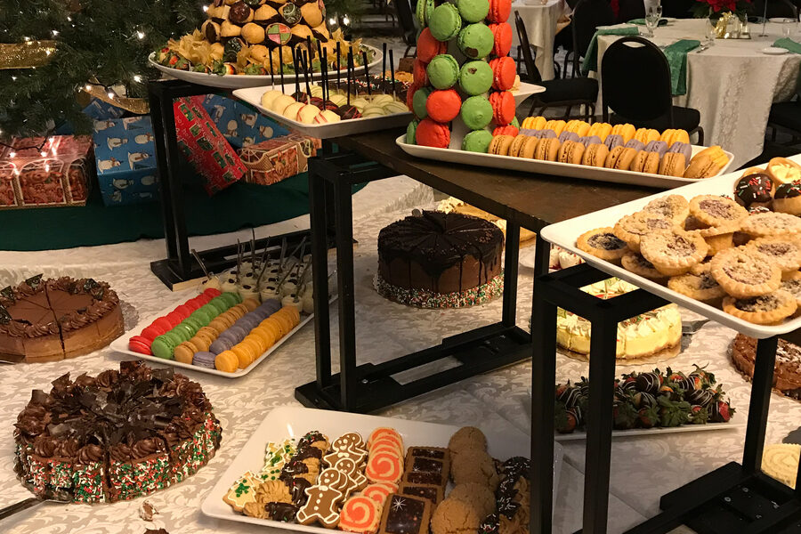 A dessert display with cakes, macarons and squares arranged on tiered stands