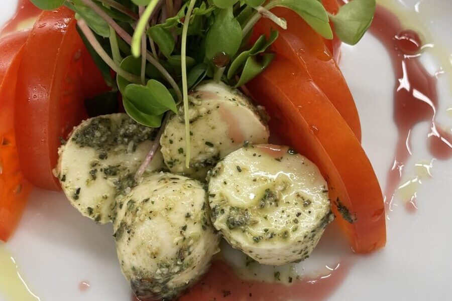 Caprese salad with pesto bocconcini, ripe tomato wedges and fresh microgreens